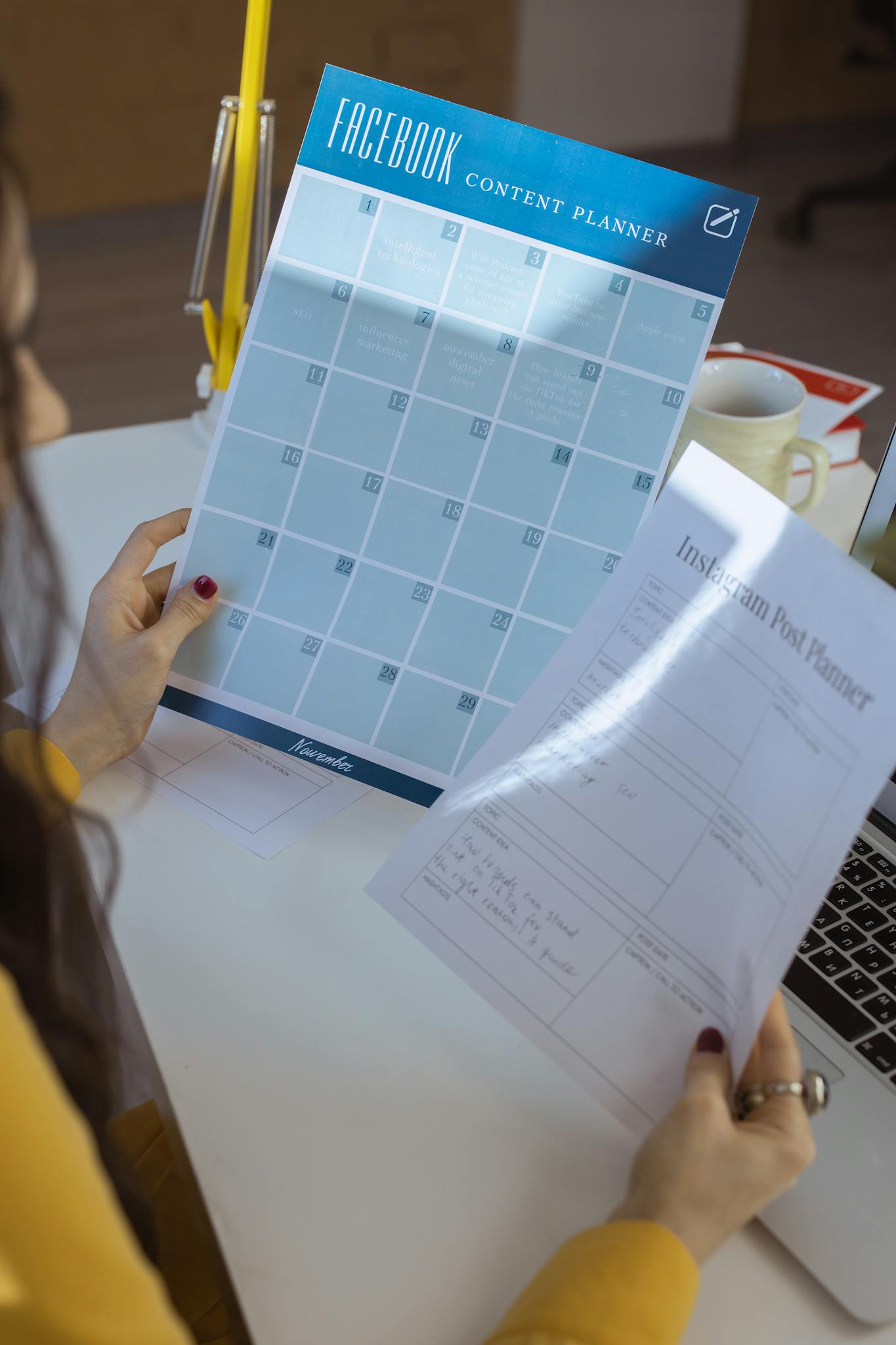 Businesswoman organizing social media strategy with content planners in a home office.